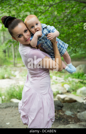 Happy mom and baby boy hugging and laughing. The concept of childhood and family. Beautiful mother and her child outdoors Stock Photo