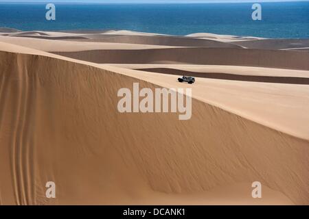 A Land Rover drives through the sand dunes of the Namib desert near Sandwich Harbour in Namib Naukluft Park south of Walvis Bay in Namibia, 2 December 2010. Photo: Tom Schulze Stock Photo