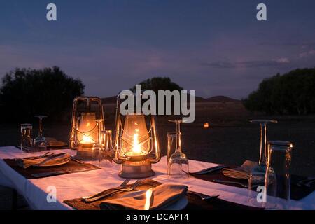 Tourists enjoy the dinner in the desert near the Rhino Desert Camp in the concession area of Wilderness Safaris near Palmwag in the Damaraland in Namibia, 10 December 2010. Photo: Tom Schulze Stock Photo