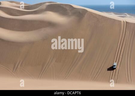 A Land Rover drives through the sand dunes of the Namib desert near Sandwich Harbour in Namib Naukluft Park south of Walvis Bay in Namibia, 2 December 2010. Photo: Tom Schulze Stock Photo