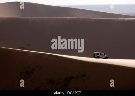 A Land Rover drives through the sand dunes of the Namib desert near Sandwich Harbour in Namib Naukluft Park south of Walvis Bay in Namibia, 2 December 2010. Photo: Tom Schulze Stock Photo