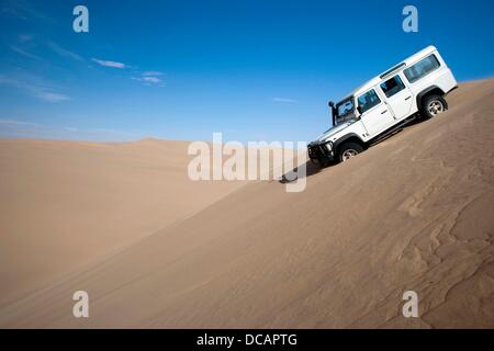 A Land Rover drives through the sand dunes of the Namib desert near Sandwich Harbour in Namib Naukluft Park south of Walvis Bay in Namibia, 2 December 2010. Photo: Tom Schulze Stock Photo