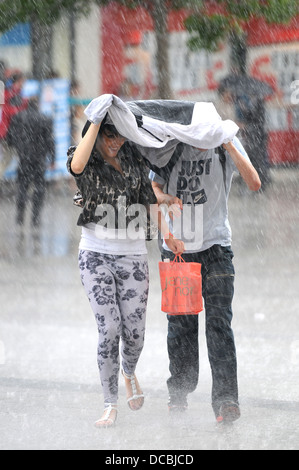 Torrential rain hits the Plymouth City centre and catching shoppers by surprise. Stock Photo