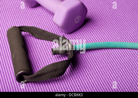 Exercise equipment on a purple yoga mat Stock Photo