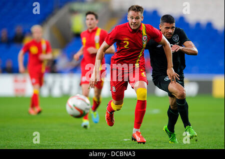 Cardiff, Wales. 14th Aug, 2013. Chris Gunter of Wales (Reading) is challenged by Shane Long of Republic of Ireland (West Bromwich Albion) during the first half of the International friendly football match between Wales and the Republic of Ireland at Cardiff City Stadium. Credit:  Action Plus Sports/Alamy Live News Stock Photo