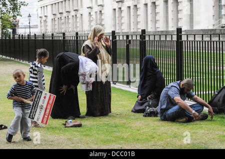 London, UK. 14th Aug, 2013. Man and Women pray at the ground of the Mall. Credit:  See Li/Alamy Live News Stock Photo