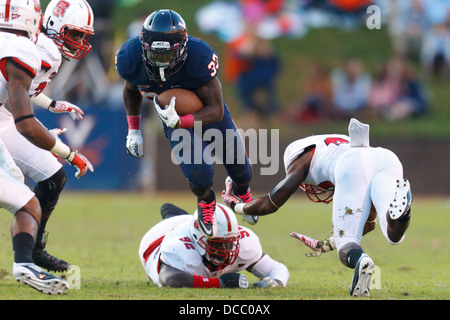 Virginia Cavaliers running back Perry Jones (33) breaks a tackle by North Carolina State Wolfpack defensive end Darryl Cato-Bish Stock Photo