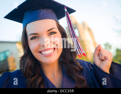 Happy Graduating Mixed Race Woman In Cap and Gown Celebrating on Campus. Stock Photo