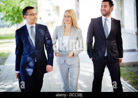 Image of friendly business team walking down street and talking Stock Photo