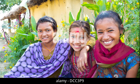 Three happy young Nepalese girls smiling in a rural Terai village ...