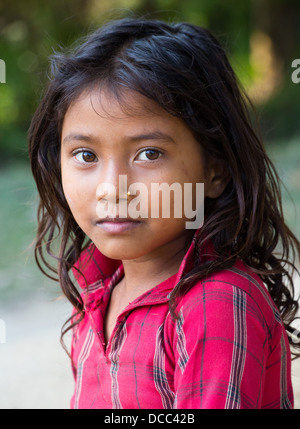 Beautiful young Tharu girl wearing a traditional cotton shirt in the Terai region in Nepal Stock Photo