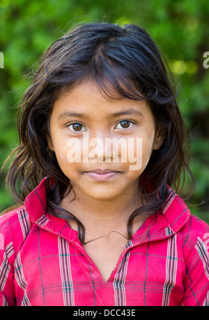Beautiful young Tharu girl wearing a traditional cotton shirt in the Terai region in Nepal Stock Photo