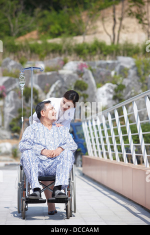 female doctor pushing a patient in a wheel chair Stock Photo