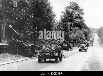Members of the German Wehrmacht travel in columns in camouflaged vehicles on the streets of the Normandy in France in July 1944. Fotoarchiv für Zeitgeschichte Stock Photo