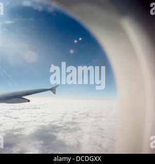 From an airliner passenger seat, bright sunshine causes lens flare during a flight across the English Channel between Paris and London. Stock Photo