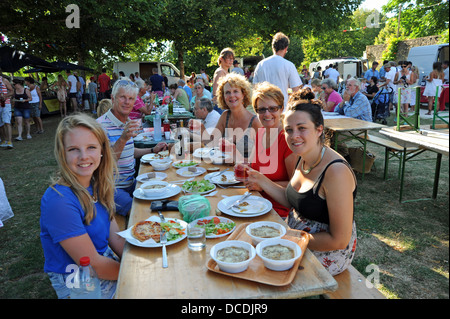 Family enjoying the village picnic evening or fete at rural village Loubejac in the Lot Region or Department of France Stock Photo