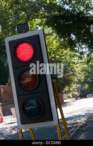 Temporary traffic lights at roadworks showing a red light. Stock Photo