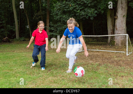 two young girls playing soccer in backyard/garden Stock Photo