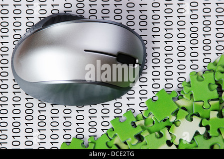 computer mouse and puzzles on a binary code Stock Photo