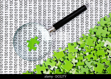 puzzles and magnifying glass on a binary code Stock Photo