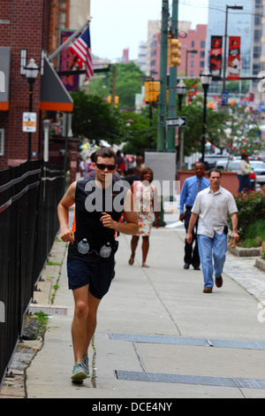 Caucasian America man running through city streets during lunch break, Baltimore, Maryland, USA Stock Photo