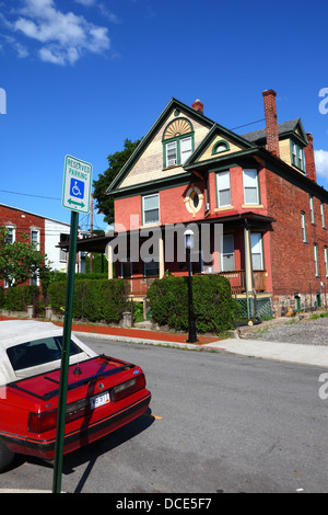Reserved disabled parking space sign and typical brick house in suburbs, Cumberland , Allegany County , Maryland , USA Stock Photo
