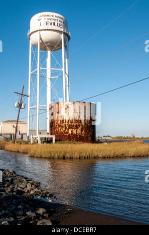 USA, Louisiana, Atchafalaya Basin, Leeville, water tower, old rusted storage tank, and telephone pole askew. Stock Photo