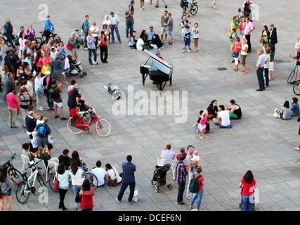 Ulm, Germany. 15th Aug, 2013. Pianist Davide Martello (C) known from the Istanbul protests plays a grand piano on Muensterplatz in Ulm, Germany, 15 August 2013. The 31 year old acheived international notoriety when he played piano on Taksim Square during the protests. Photo: Ozlem Yilmazer/dpa/Alamy Live News Stock Photo