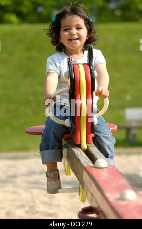 Toddler girl on a seesaw on the playground Stock Photo