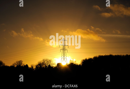 SETTING SUN BEHIND ELECTRICITY PYLON SOLAR POWER Stock Photo
