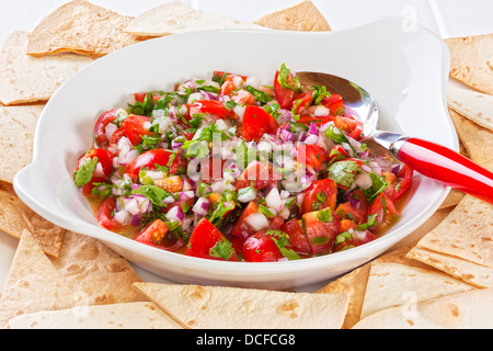Pico de gallo, or salsa fresca, is a fresh, uncooked relish in Mexican cuisine, made from tomatoes, red onion, chilli, olive... Stock Photo