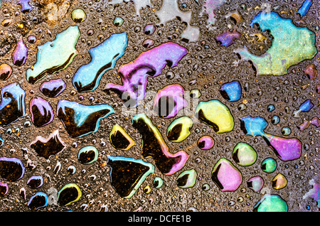 Iridescent water droplets on tarmac caused by oily road surface Stock Photo