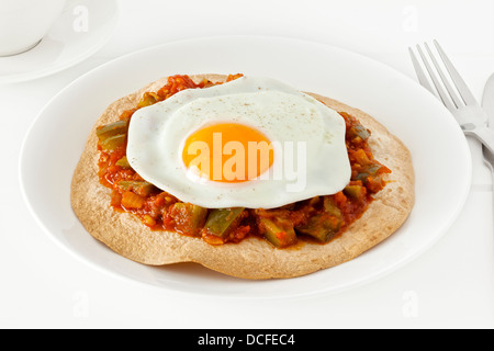 Huevos Rancheros - Mexican style breakfast of a tortilla, topped with salsa ranchera and a free range fried egg. Stock Photo