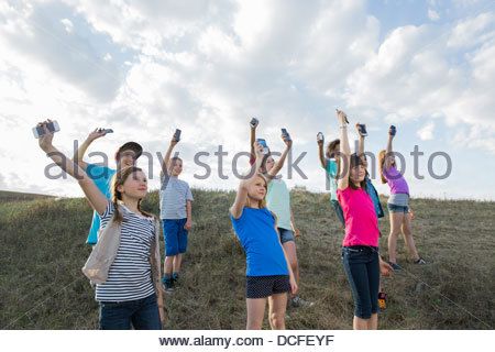 Schoolchildren holding mobile phones up