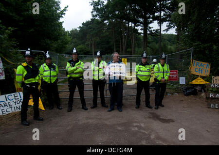 16th August 2013.  Balcombe  West Sussex, UK An anti fracking protester stands in front of a police line protecting the entrance to the drilling site. Hundreds of anti fracking protesters gather on the village of Balcombe as energy company Cuadrilla plans to scale down drilling operations on police advice Stock Photo