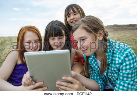 Group of young girls looking at digital tablet outdoors