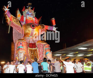 Kajang, SELANGOR, MALAYSIA. 17th Aug, 2013. Kajang, SELANGOR, MALAYSIA. 16th Aug, 2013. Ethnic Chinese devottees carry of a giant paper-made statue of Chinese deity know as 'Da Shi Ye' or 'Guardian God of Ghosts' to set on fire during the festive event of Hungry Ghost in Kajang, Malaysia. In Chinese tradition the seventh month of the lunar year is regarded as the Ghost Month in which spirits and ghosts come down to earth. During this festival the devotees burn paper-made models to appease the wandering spirits and offers prayers. Credit:  Kamal Sellehuddin/ZUMAPRESS.com/Alamy Live News Stock Photo