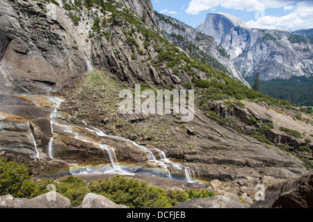 Rainbow over middle part of Yosemite Falls with Half Dome in background Stock Photo