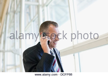 Businessman using mobile phone by window