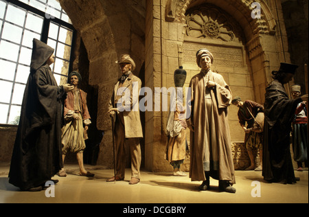 Puppets depicting typical figures in Jerusalem at the end of Ottoman period standing in front of a detailed model of Sabil or Sebil of Suleyman displayed at the Citadel museum in David Tower old city East Jerusalem Israel Stock Photo