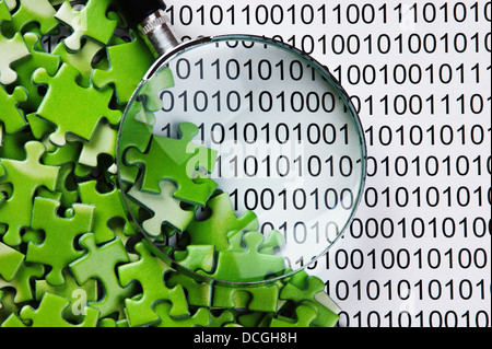 puzzles and magnifying glass on a binary code Stock Photo