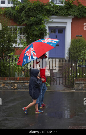 Lyme Regis, UK 17 August 2013. Tourists brave the wet weather. Walking along the streets under umbrella trying to keep dry under the shelter. Credit:  Carolyn Jenkins/Alamy Live News Stock Photo