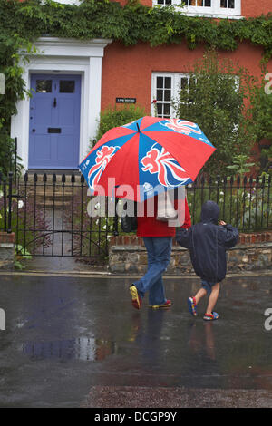 Lyme Regis, UK 17 August 2013. Tourists brave the wet weather. Walking along the streets under umbrella trying to keep dry under the shelter. Credit:  Carolyn Jenkins/Alamy Live News Stock Photo