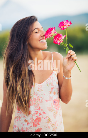 Beautiful Young Woman Smelling Flowers in Countryside, Summer Lifestyle Stock Photo