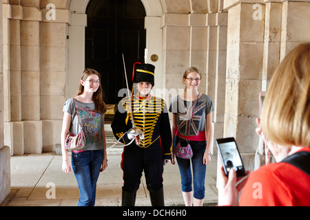 female royal horse artillery officer stands with tourists for photos London England UK Stock Photo