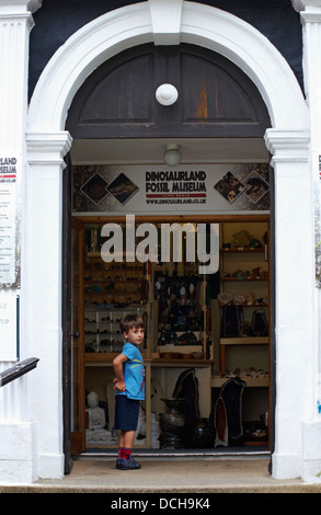 young lad at entrance to Dinosaurland Fossil Museum at Lyme Regis, Dorset UK in August Stock Photo