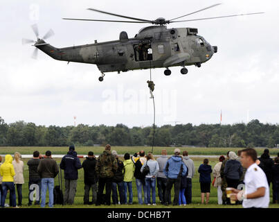 Visitors look at a demonstration by a type Seaking helicopter during airday at airfield 'Graf Zeppelin' in Nordholz, Germany, 18 August 2013. The open day at the Bundeswehr's biggest military airfield was organized on the occasion of the 100th anniversary of German Naval aviation. Photo: INGO WAGNER Stock Photo