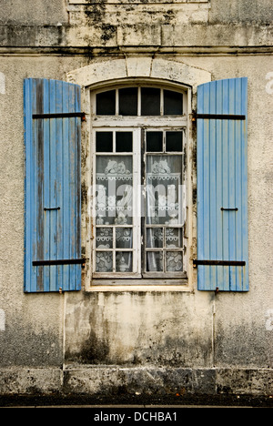 House with blue shutters at the window Stock Photo
