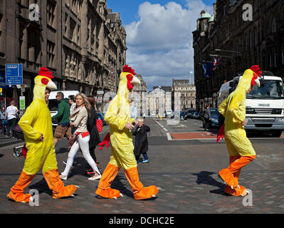Edinburgh, UK. 18th Aug, 2013. Edinburgh Fringe Festival. Pedestrians appear to be wondering why these visitors from Hertfordshire are crossing the road dressed as chickens but few things surprise during the Edinburgh Fringe Festival season Stock Photo