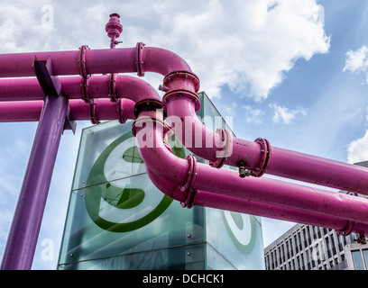 The pink water drainage pipes that drain ground water from Construction sites and S-bahn station sign against a cloudy blue sky - Berlin Stock Photo